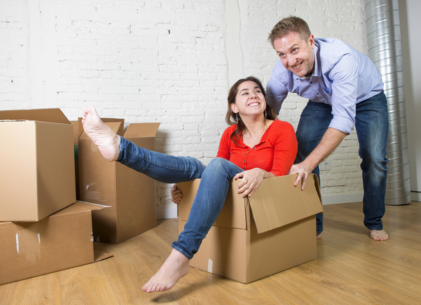 happy American couple unpacking moving in new house playing with - Photo, Image