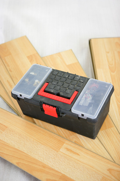 Tool box resting on laminate floorboards - Foto, imagen