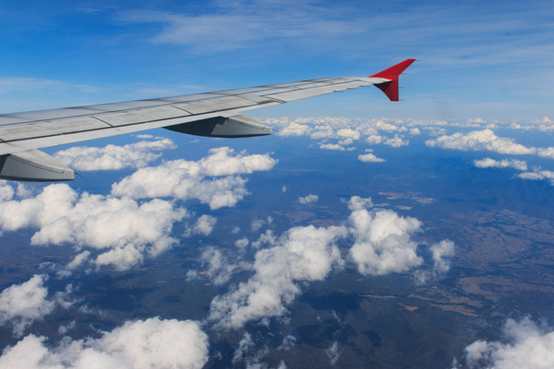 Görünümü bir uçak pencereden görüldüğü gibi kanat ve güzel bulutlar gökyüzü - Fotoğraf, Görsel