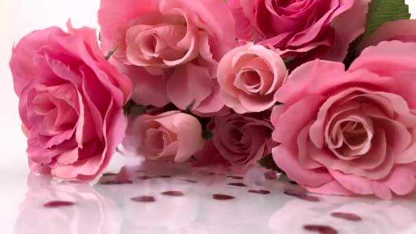 Pequeños corazones de San Valentín lloviendo sobre rosas rosadas
 - Imágenes, Vídeo