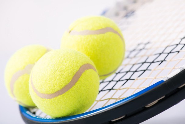 Three tennis balls and a racket. - Zdjęcie, obraz