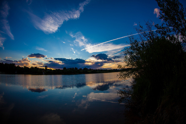blauwe avondlucht en glad wateroppervlak - Foto, afbeelding