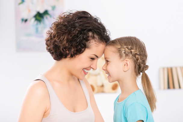 Mother and daughter are grinning to each other. - Foto, Bild