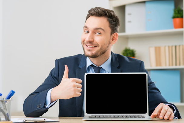 Diligent office worker pointing out his laptop - Photo, image