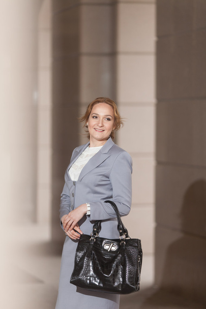 Red haired business women in grey suit - Foto, Bild