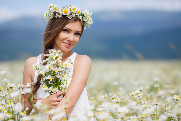 Beautiful young woman in a field of blooming daisies - Φωτογραφία, εικόνα