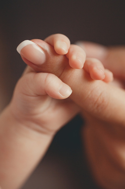 Newborn baby holding mother's finger - Photo, Image