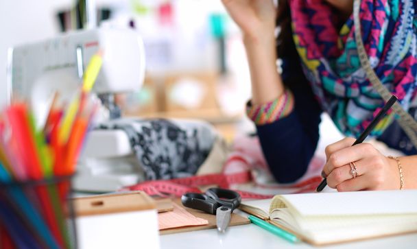 Dressmaker designing clothes pattern on paper - Фото, изображение