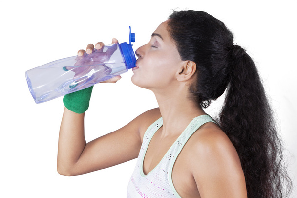 Indian woman drinking water after workout - Foto, afbeelding