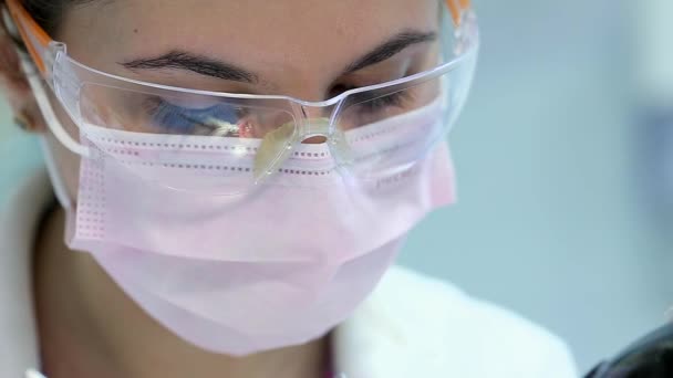 Attractive Doctor Dentist in Protective Glasses at Work - Кадры, видео
