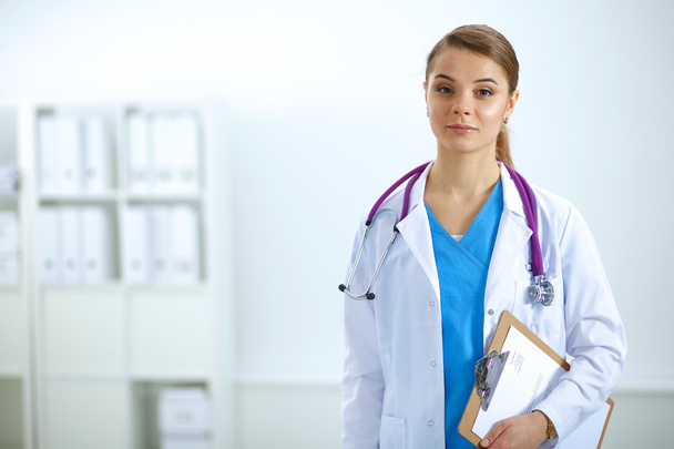 Woman doctor standing with folder at hospital - Φωτογραφία, εικόνα