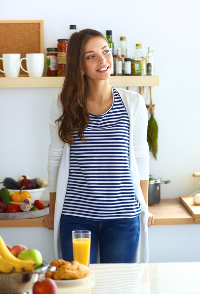 Young woman standing in kitchen at home - Foto, Imagem