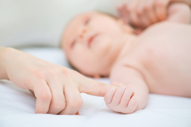 Infant holding finger of the mother - 写真・画像