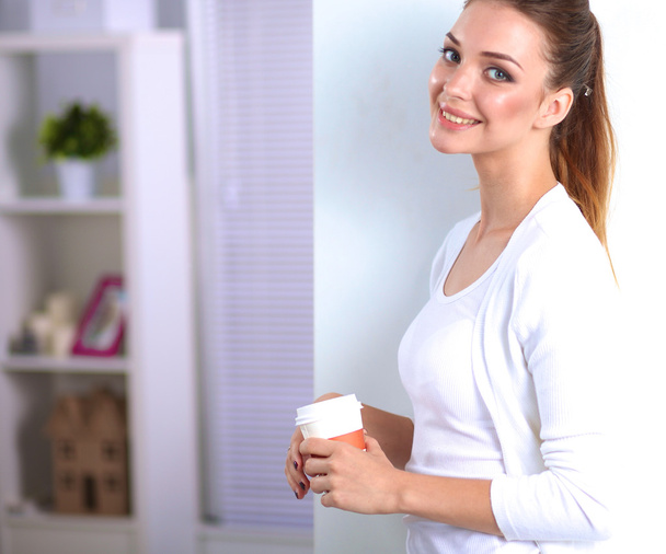 Attractive young businesswoman standing  near wall in office - Photo, image