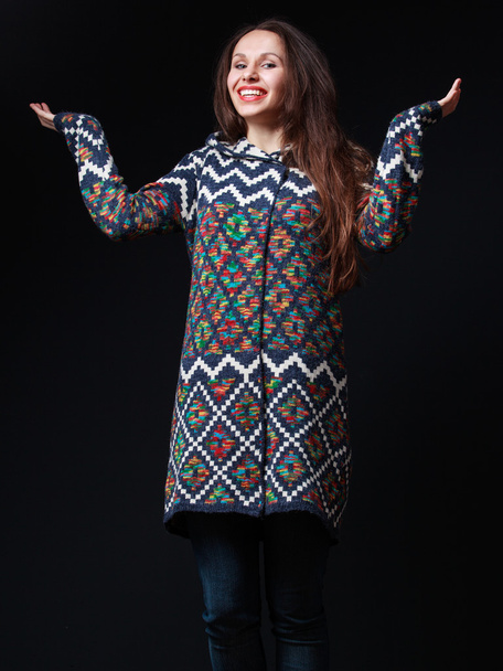 Young brunette woman in bright sweater smiling, raising  hands - Photo, Image