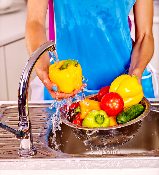 Woman washing fruit at kitchen. - Fotó, kép