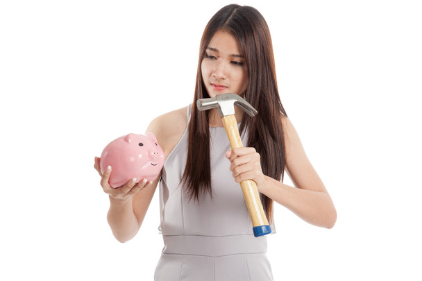Beautiful young Asian woman with piggy bank and hammer - Foto, imagen