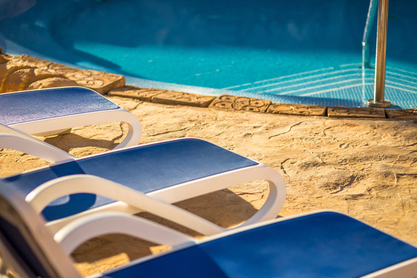 Closeup αρκετές από ξαπλώστρες από μία πανέμορφη πισίνα. - Φωτογραφία, εικόνα