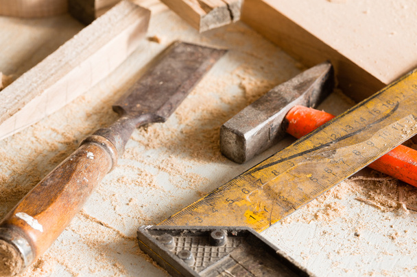 Hammer, chisel and angle carpenter lie on a workbench  - Fotó, kép