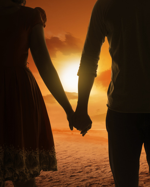 young couple holding hands on a beach - Valokuva, kuva