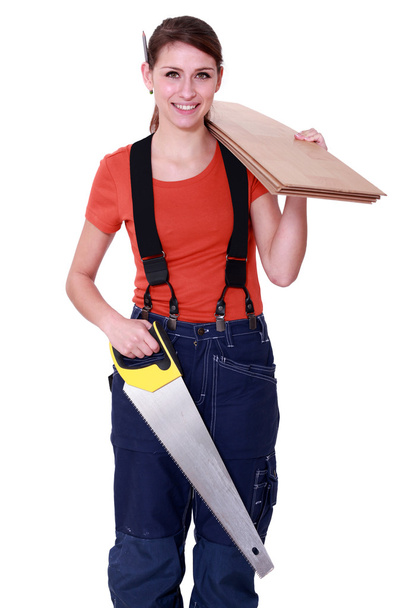 Woman carrying plywood and a saw - Foto, Imagem