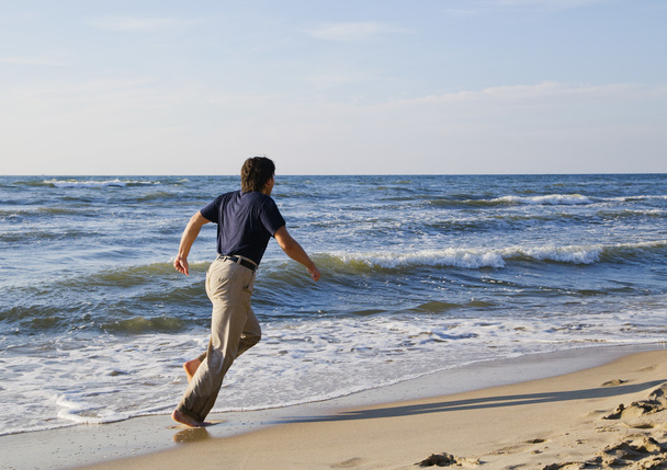 Man running along seashore - Фото, зображення