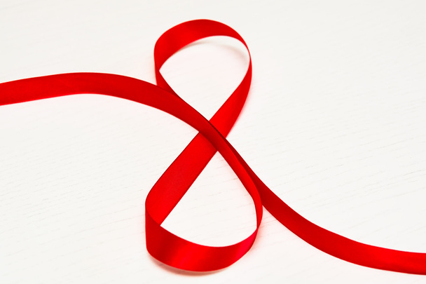 Happy Women's Day. Red gift ribbon in 8 digit shape  - Фото, изображение
