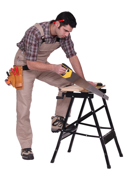 Handyman sawing a plank of wood - Photo, Image