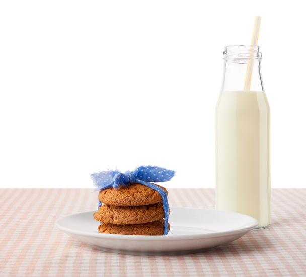 Oatmeal cookies on white ceramic plate and bottle of milk  - Fotoğraf, Görsel