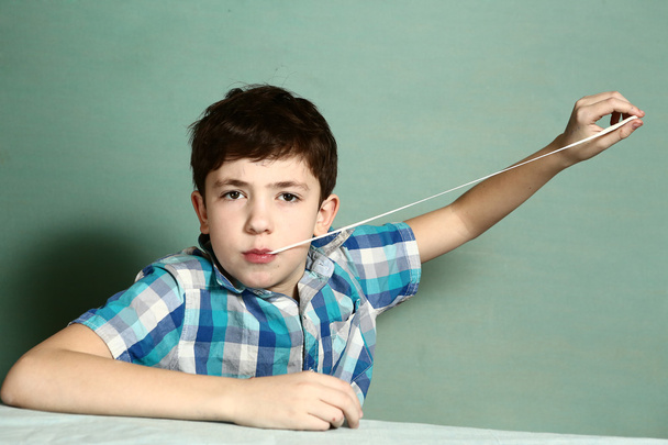  Junge zieht Kaugummi mit der Hand aus Motte - Foto, Bild