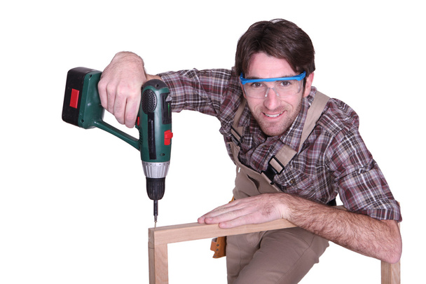 Man drilling into wooden frame - Фото, зображення