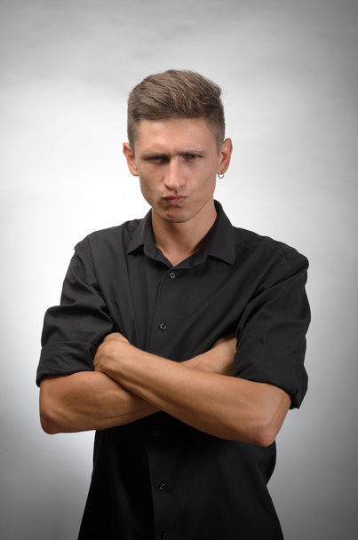 Portrét pohledný mladý muž stál s rukama založenýma šedé pozadí - Fotografie, Obrázek
