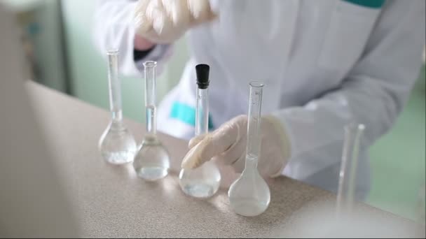 Tutkija työskentelee nesteiden kanssa kemiallisessa laboratoriossa
 - Materiaali, video
