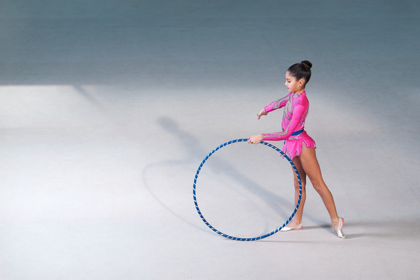 gymnast in a  pink suit doing hoop exercise - Φωτογραφία, εικόνα