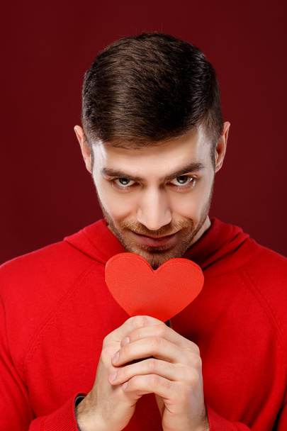 cute guy with a red heart in the hands close up - Foto, Imagen