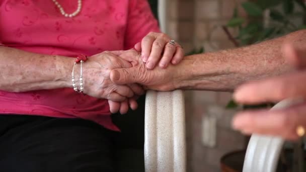 A close up shot an eldery woman holding an elderly man's hand. - Filmati, video