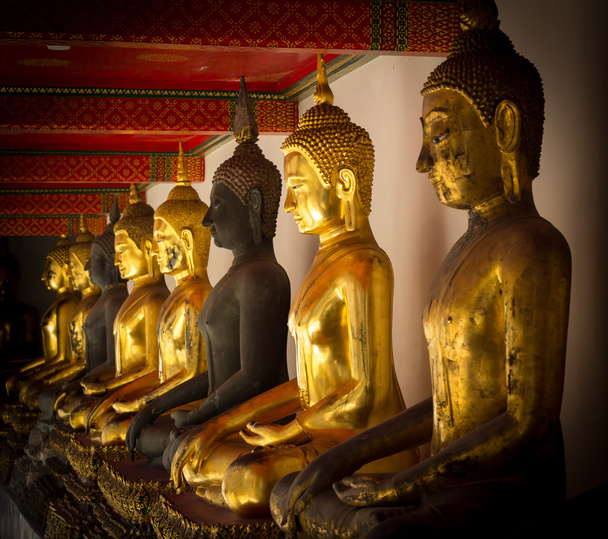 Reihe goldener sitzender Buddhas in einem buddhistischen Tempel - Foto, Bild