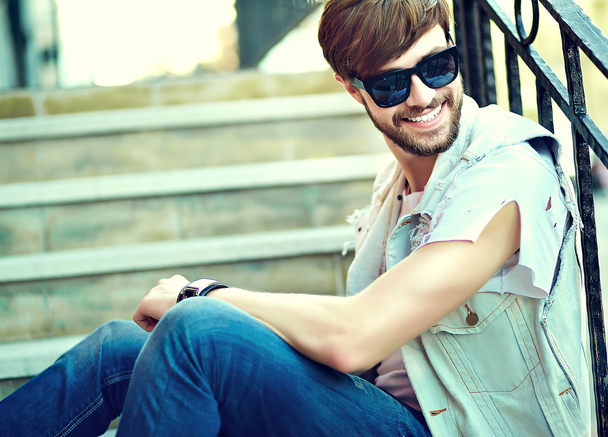 Funny smiling hipster handsome man guy in stylish summer clothes in the street - Photo, image