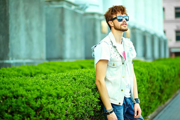 Funny smiling hipster handsome man guy in stylish summer clothes in the street - 写真・画像