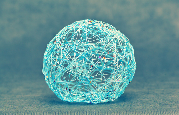 Мяч, шар крупным планом из ниток и украшен цветными бусами. декоративный бал
 - Фото, изображение