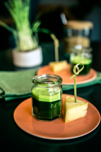 Listovou zeleninu šťáva s kouskem ananasu na desku v restauraci - Fotografie, Obrázek