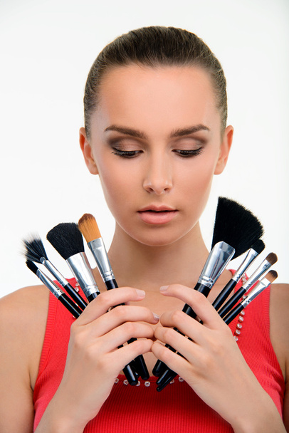 Jeune femme tenant des pinceaux de maquillage
. - Photo, image
