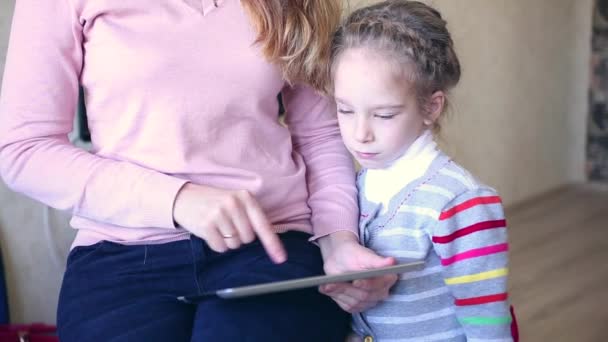 Mother and daughter playing with electronic tablet - Materiał filmowy, wideo