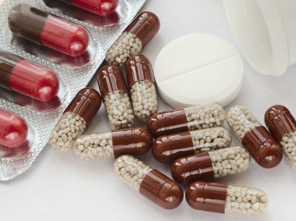 tabletten en pillen zijn op een lichte ondergrond - Foto, afbeelding