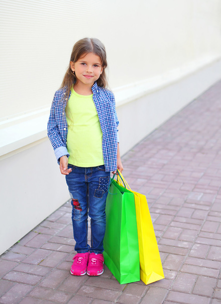 Beautiful little girl child with shopping paper bags walking in  - Фото, зображення