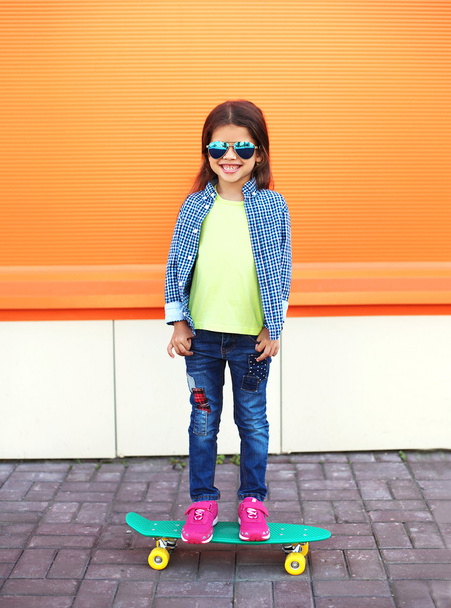 Happy cheerful smiling stylish little girl child with skateboard - Photo, Image