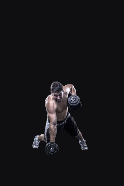 Чоловічий спортсмен робить вправи з гантелями ізольовані на чорному тлі
 - Фото, зображення