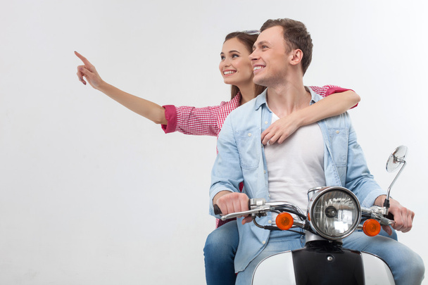 Cheerful boyfriend and girlfriend on a motorbike - 写真・画像