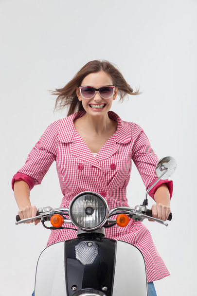 Beautiful young girl is riding the motorbike - 写真・画像