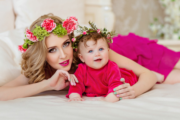 Beautiful slim blonde mom in red dress and a wreath of flowers l - Fotoğraf, Görsel